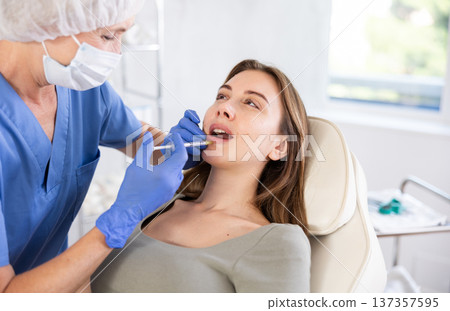 Young woman getting lip fillers. Young woman getting lip fillers. 137357595