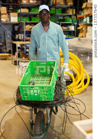 African-american man carrying trolley with building materials African-american man carrying trolley with building materials 137357640