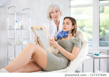Young patient looking in mirror at clinic. Young patient looking in mirror at clinic. 137357680
