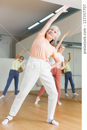 Mature woman with family enjoying active dances in dance studio 137357707