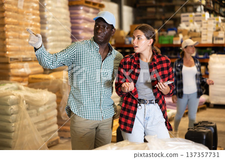 Man and woman having conversation in warehouse 137357731