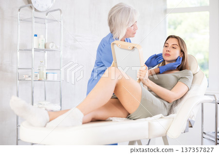 Young patient looking in mirror at clinic. Young patient looking in mirror at clinic. 137357827