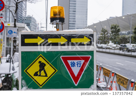 Construction sign on a snowy day: slow down and road construction warning Construction sign on a snowy day: slow down and road construction warning 137357842