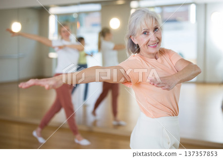 Mature woman with family learning swing steps at dance class Mature woman with family learning swing steps at dance class 137357853
