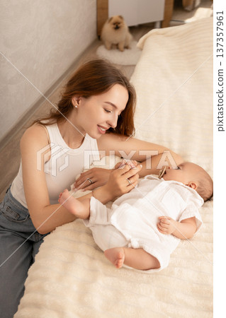 Mother plays with her baby in a warm, inviting space 137357961