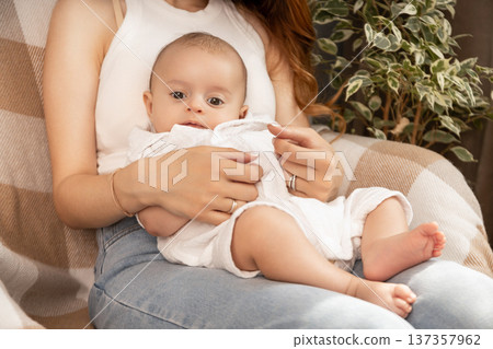 A loving mother enjoys a moment with her curious baby at home 137357962