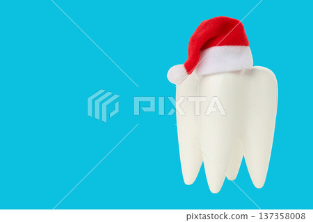 A tooth in a Santa hat on a blue background A tooth in a Santa hat on a blue background 137358008