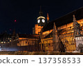 Big Ben clock tower seen from behind iron fencing at night. The layered view adds depth to London city landmark imagery. 137358533