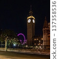 Big Ben clock tower seen from behind iron fencing at night. The layered view adds depth to London city landmark imagery. 137358536