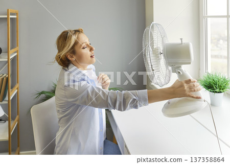 Sweating Woman Using Fan During Hot Weather Sweating Woman Using Fan During Hot Weather 137358864