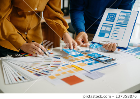 UX developer and ui designer brainstorming about mobile app interface wireframe design with customer breif and color code 137358876
