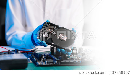 Hard disk drive on the technician's desk and a computer motherboard as a component. the concept of data, hardware, and information technology. Hard disk drive on the technician's desk and a computer motherboard as a component. the concept of data, hardware, and information technology. 137358907