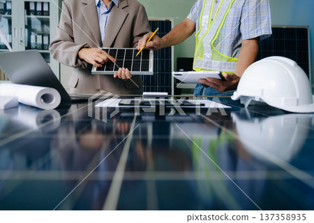Engineers collaborate on solar and wind energy, driving sustainability, innovation, and clean tech solutions. 137358935