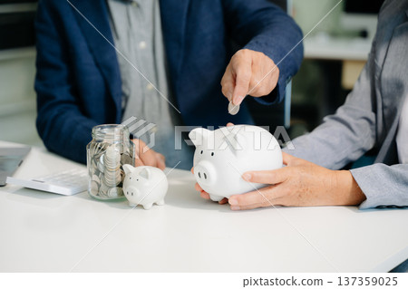 business team holding coins putting in glass with using smartphone and calculator business team holding coins putting in glass with using smartphone and calculator 137359025