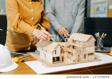 Engineer desk with object paper and tablet with blurry engineer teamwork hardworking Engineer desk with object paper and tablet with blurry engineer teamwork hardworking 137359044
