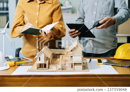 Engineer desk with object paper and tablet with blurry engineer teamwork hardworking Engineer desk with object paper and tablet with blurry engineer teamwork hardworking 137359046
