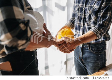 Engineer and contractor join hands after signing contract,They are having a modern building project together. 137359063