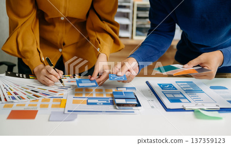 UX developer and ui designer brainstorming about mobile app interface wireframe design with customer breif and color code 137359123