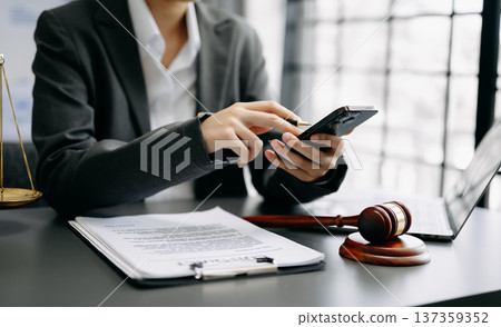 justice and law concept. Male judge in a courtroom the gavel, working with smart phone and laptop and digital tablet computer on desk justice and law concept. Male judge in a courtroom the gavel, working with smart phone and laptop and digital tablet computer on desk 137359352