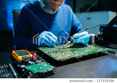 Professional electronics engineer testing a circuit board in a modern laboratory, concept of technology, repair, innovation, engineering 137359386