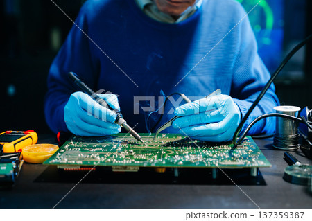 Professional electronics engineer testing a circuit board in a modern laboratory, concept of technology, repair, innovation, engineering Professional electronics engineer testing a circuit board in a modern laboratory, concept of technology, repair, innovation, engineering 137359387