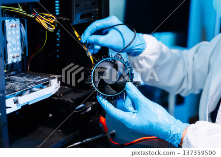 IT technician repairing computer hardware and cooling fan inside server system. Technology maintenance, cybersecurity infrastructure, data center IT technician repairing computer hardware and cooling fan inside server system. Technology maintenance, cybersecurity infrastructure, data center 137359500