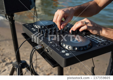 Close up of DJ's hands while working outdoors.  137359605