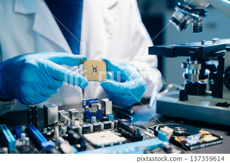 The technician is putting the CPU on the socket of the computer motherboard. electronic engineering electronic repair, electronics measuring The technician is putting the CPU on the socket of the computer motherboard. electronic engineering electronic repair, electronics measuring 137359614