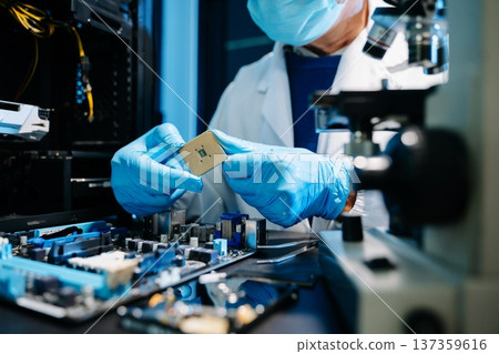 The technician is putting the CPU on the socket of the computer motherboard. electronic engineering electronic repair, electronics measuring and testing, repair The technician is putting the CPU on the socket of the computer motherboard. electronic engineering electronic repair, electronics measuring and testing, repair 137359616