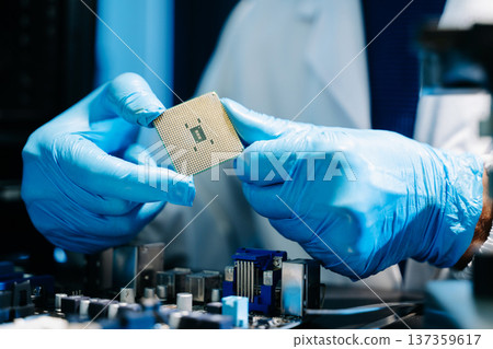 The technician is putting the CPU on the socket of the computer motherboard. electronic engineering electronic repair, electronics measuring and testing, repair 137359617
