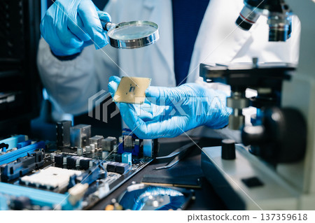 The technician is putting the CPU on the socket of the computer motherboard. electronic engineering electronic repair, electronics measuring and testing, repair 137359618