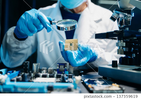 The technician is putting the CPU on the socket of the computer motherboard. electronic engineering electronic repair, electronics measuring and testing, repair 137359619