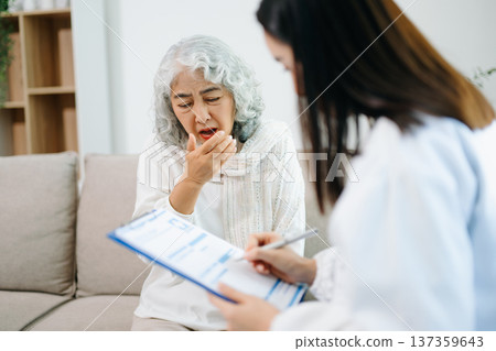 Healthcare professional using stethoscope to examine elderly woman at home. Senior medical checkup, heart health, home care, diagnosis, prevention Healthcare professional using stethoscope to examine elderly woman at home. Senior medical checkup, heart health, home care, diagnosis, prevention 137359643