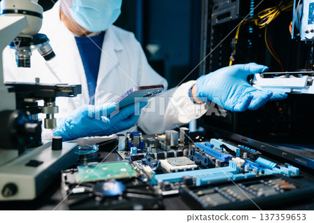 IT technician repairing smartphone in a modern electronics lab. Precision work with tools, motherboard diagnostics, and mobile repair in a professional tech workspace. 137359653