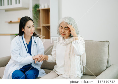 Female doctor supporting elderly woman at home during medical visit. Senior healthcare, home care, patient support, wellness, trust and professional medical assistance concept. Female doctor supporting elderly woman at home during medical visit. Senior healthcare, home care, patient support, wellness, trust and professional medical assistance concept. 137359732