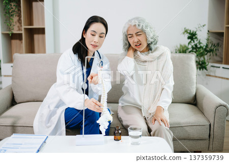 Doctor examining elderly woman with knee pain during home healthcare visit, highlighting arthritis treatment, senior support, medical consultation and compassionate care. 137359739