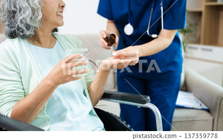 Female doctor explaining ear anatomy to elderly woman during home medical consultation. Hearing care, senior health, audiology, prevention, wellness and healthcare Female doctor explaining ear anatomy to elderly woman during home medical consultation. Hearing care, senior health, audiology, prevention, wellness and healthcare 137359778