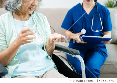 Female doctor explaining ear anatomy to elderly woman during home medical consultation. Hearing care, senior health, audiology, prevention, wellness and healthcare Female doctor explaining ear anatomy to elderly woman during home medical consultation. Hearing care, senior health, audiology, prevention, wellness and healthcare 137359779