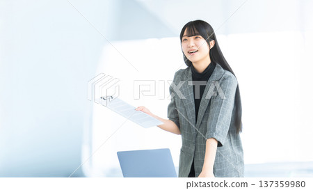 一位年輕女子/女商人手持文件,正在發表聲明/提出建議。 一位年輕女子/女商人手持文件,正在發表聲明/提出建議。 137359980