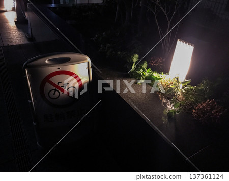 Public telephone illuminated by street lights at night 137361124