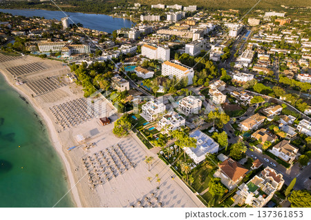 Majorca Balearic Islands coastal town with buildings beside beach water, sunbeds arranged on sand at Spain Majorca Balearic Islands coastal town with buildings beside beach water, sunbeds arranged on sand at Spain 137361853