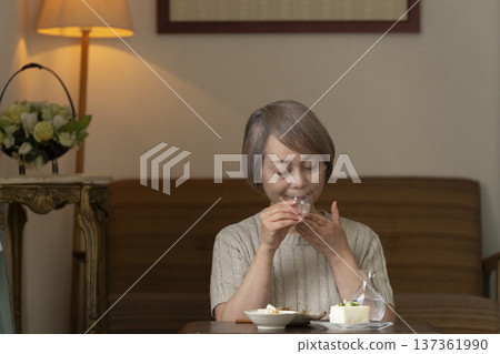 一位老婦人在客廳喝飲料 一位老婦人在客廳喝飲料 137361990