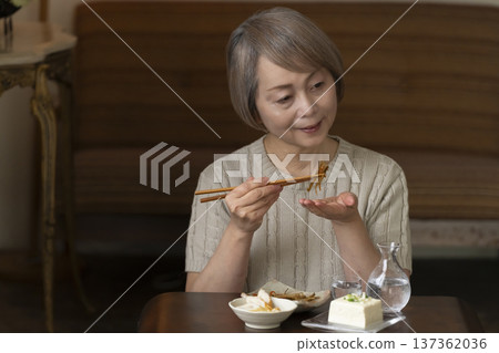 一位老婦人在客廳喝飲料 137362036