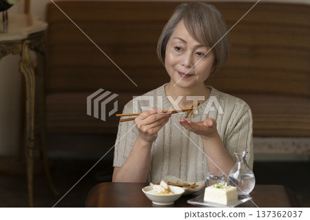 一位老婦人在客廳喝飲料 一位老婦人在客廳喝飲料 137362037