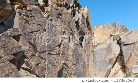 Stone wall texture background. Rock with the image of the sun-headed god. Stone wall texture background. Rock with the image of the sun-headed god. 137362567