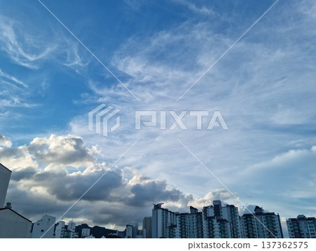 It's a landscape with blue sky and apartments. 137362575