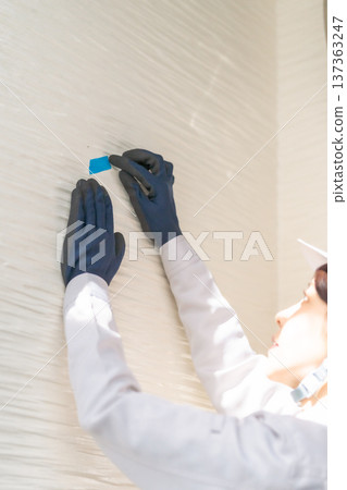 一位女工程師正在標記並檢查外牆 一位女工程師正在標記並檢查外牆 137363247