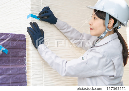 一位女工程師正在標記並檢查外牆 一位女工程師正在標記並檢查外牆 137363251