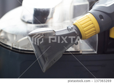 Close up view of transparent nozzle head from professional wet vacuum cleaner machine for deep cleaning of sofa and upholstery fabric. 137363269