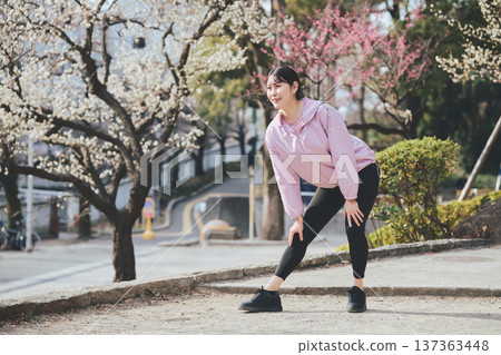 A woman stretching outdoors. Warming up before and after running. Healthy exercise habits. 137363448